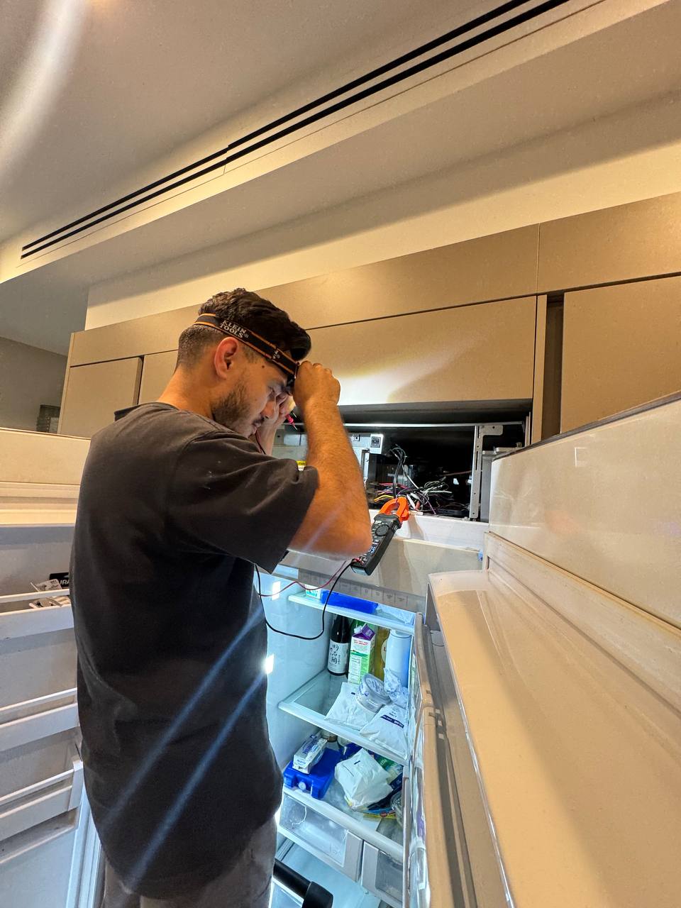 Up-liance Appliance Repair founder repairing a refrigerator